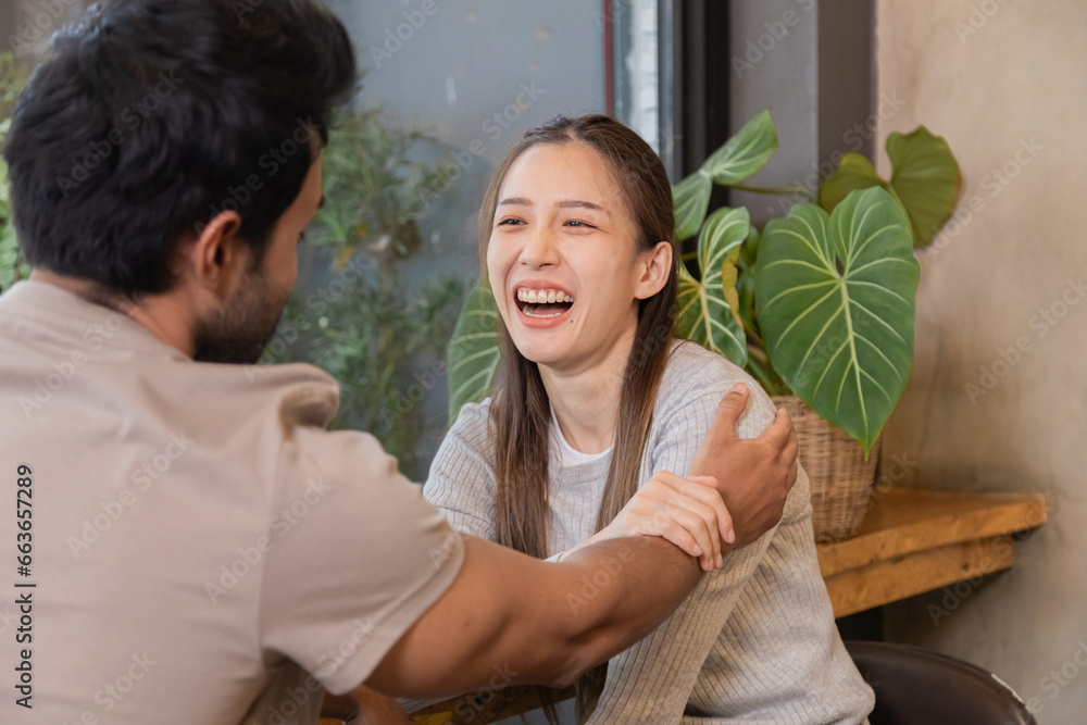 Fototapeta premium Lifestyle small business couple bonding happy working together in cafe coffee shop, cheerful wife talking to husband or consulting project start-up planning, man and woman spending time on holiday