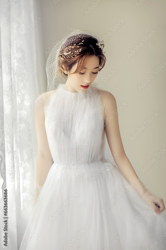 Asian girl in beautiful wedding dress in front of screen window Asian girl in beautiful wedding dress in front of screen window