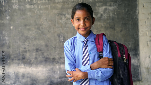 Portrait of happy indian teenager school boy with backpack holding books. Smiling young asian male kid looking at camera.