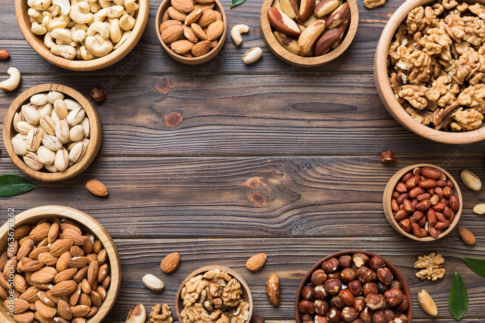 mixed nuts in wooden bowl. Mix of various nuts on colored background. pistachios, cashews, walnuts, hazelnuts, peanuts and brazil nuts mixed nuts in wooden bowl. Mix of various nuts on colored background. pistachios, cashews, walnuts, hazelnuts, peanuts and brazil nuts