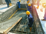 Workers concrete casting work. using concrete vibrator for compacting concrete of stiff consistency
