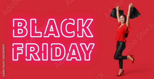 Beautiful happy Asian woman with shopping bags and text BLACK FRIDAY on red background