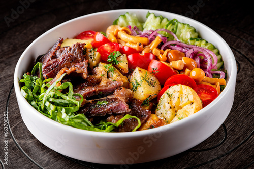 Cobb salad. Classic American salad with tomato, bacon, grilled beef, eggs,mushroom, potato, cucumber on plate