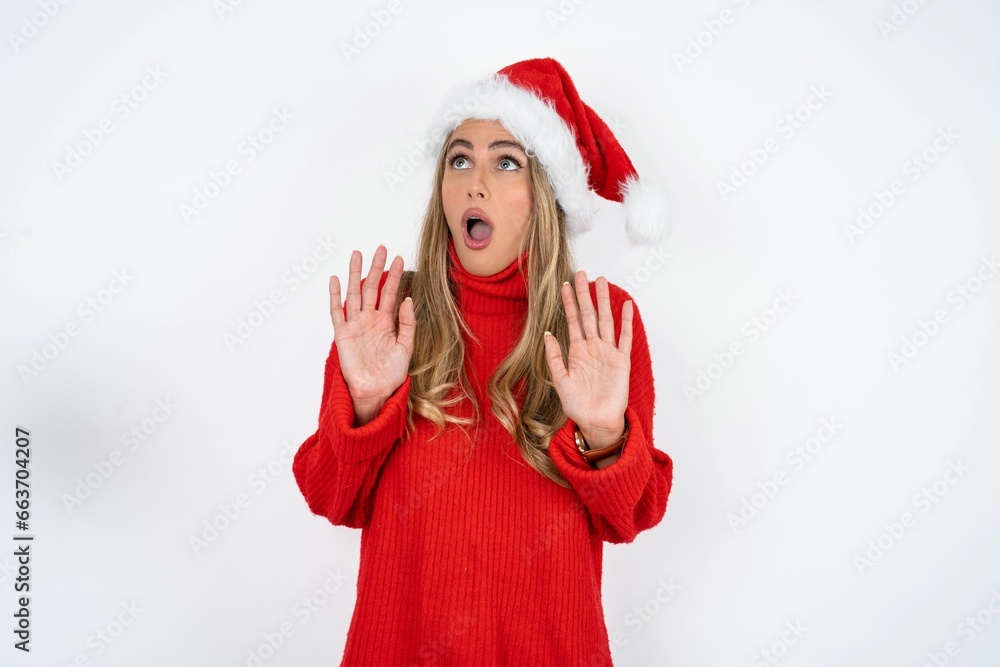 Young beautiful woman keeps palms forward and looks with fright above on ceiling tries to defense herself from invisible danger opens mouth. Young beautiful woman keeps palms forward and looks with fright above on ceiling tries to defense herself from invisible danger opens mouth.
