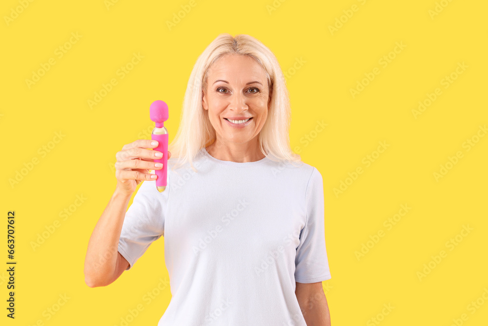 Mature woman with vibrator on yellow background Mature woman with vibrator on yellow background