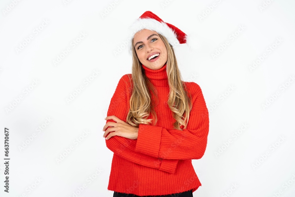 Portrait of charming Beautiful hispanic woman wearing christmas hat and red knitted sweater standing confidently smiling toothily with hands folded Portrait of charming Beautiful hispanic woman wearing christmas hat and red knitted sweater standing confidently smiling toothily with hands folded