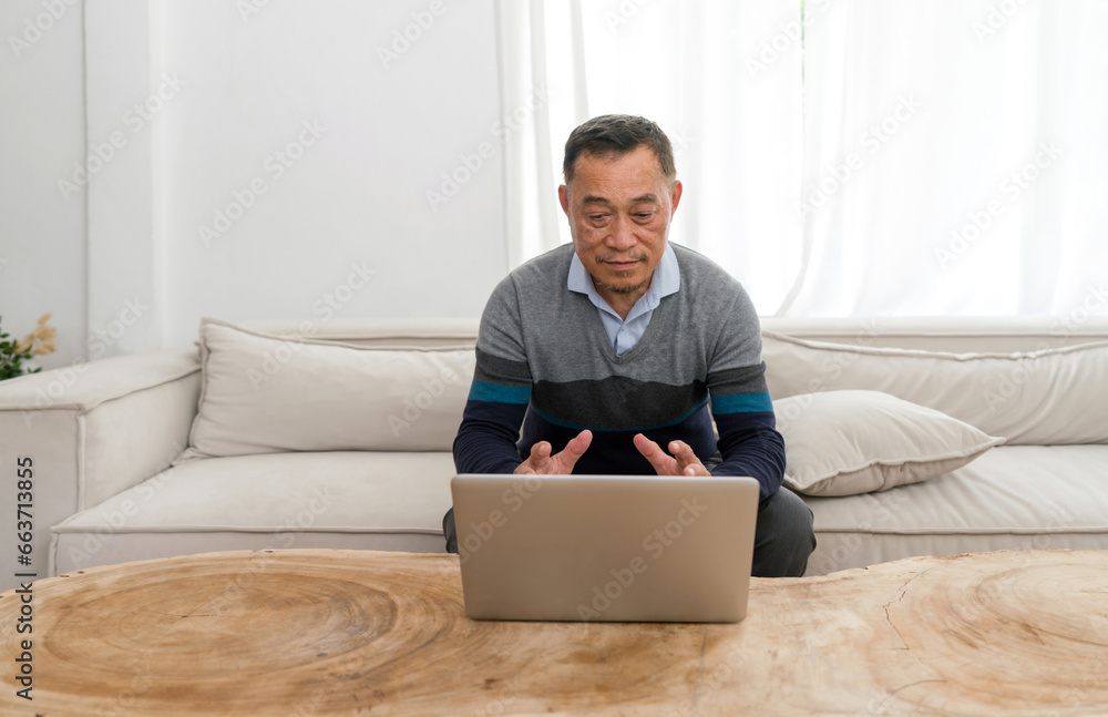 Old man relaxing comfortably on a sofa, immersed in operating a laptop. Evident focus and concentration in a cozy domestic backdrop. Old man relaxing comfortably on a sofa, immersed in operating a laptop. Evident focus and concentration in a cozy domestic backdrop.