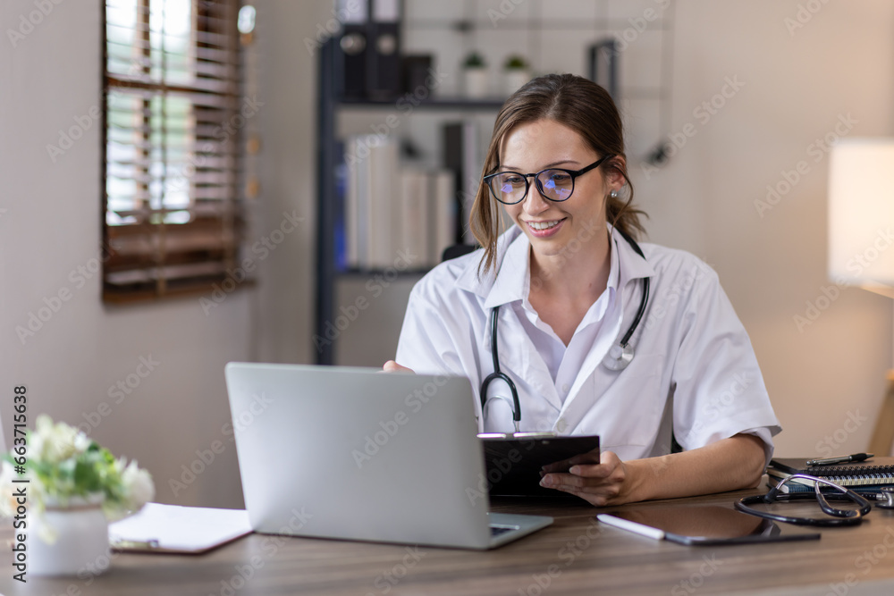 Young lady doctor in white medical uniform using laptop talking video conference call with senior doctor at desk,Doctor sitting at desk and writing a prescription for her patient Young lady doctor in white medical uniform using laptop talking video conference call with senior doctor at desk,Doctor sitting at desk and writing a prescription for her patient