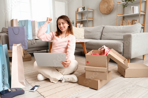 Young woman with laptop sho...