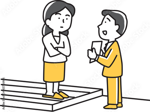 玄関で主婦に説明しているビジネスマン