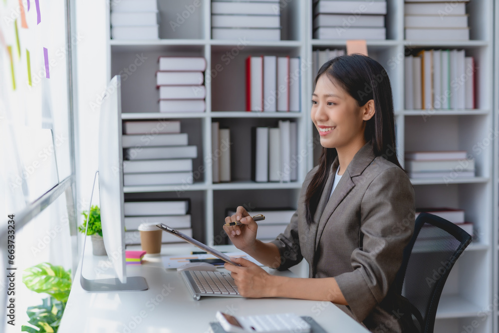 Asian businesswoman smiling using laptop computer at office. Confident Asia businesswoman sitting happily in the office. Asian businesswoman smiling using laptop computer at office. Confident Asia businesswoman sitting happily in the office.