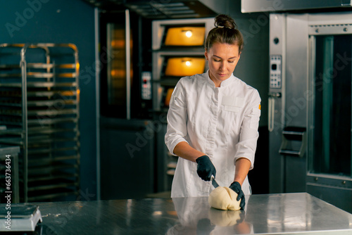 Fotografia professional female baker in the kitchen forms the dough into perfect bread shap