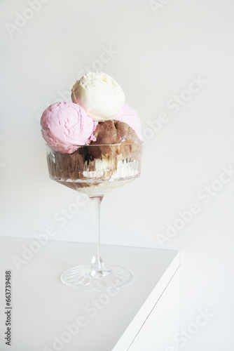 Vanilla  chocolate and strawberry ice cream scoops in glass on white background