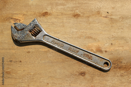 Rusty English wrench on wood table background, kunci inggris  photo