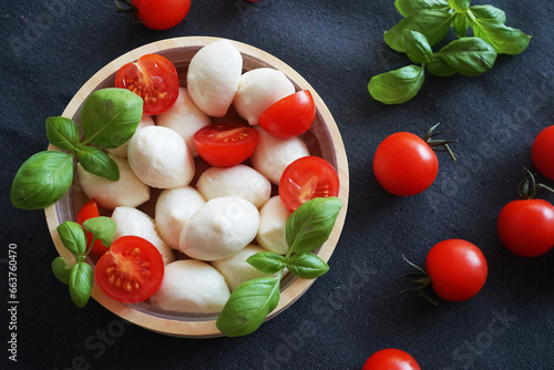 Mozzarella with cherry tomatoes with basil on a dark gray background