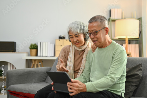 Photography Happy senior couple spending time together at home and using digital tablet for