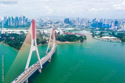 a big red bridge standing over a river and a big city. AI GENERATE photo
