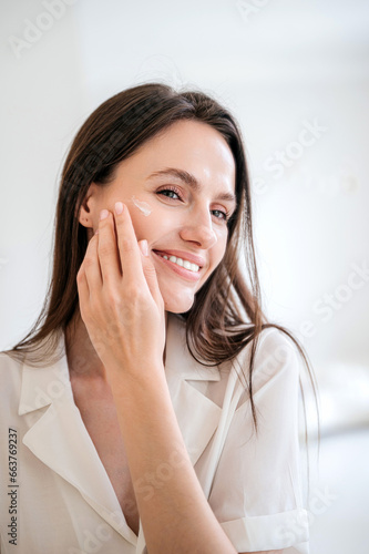 Canvastavla Woman applying under eye cream at her face