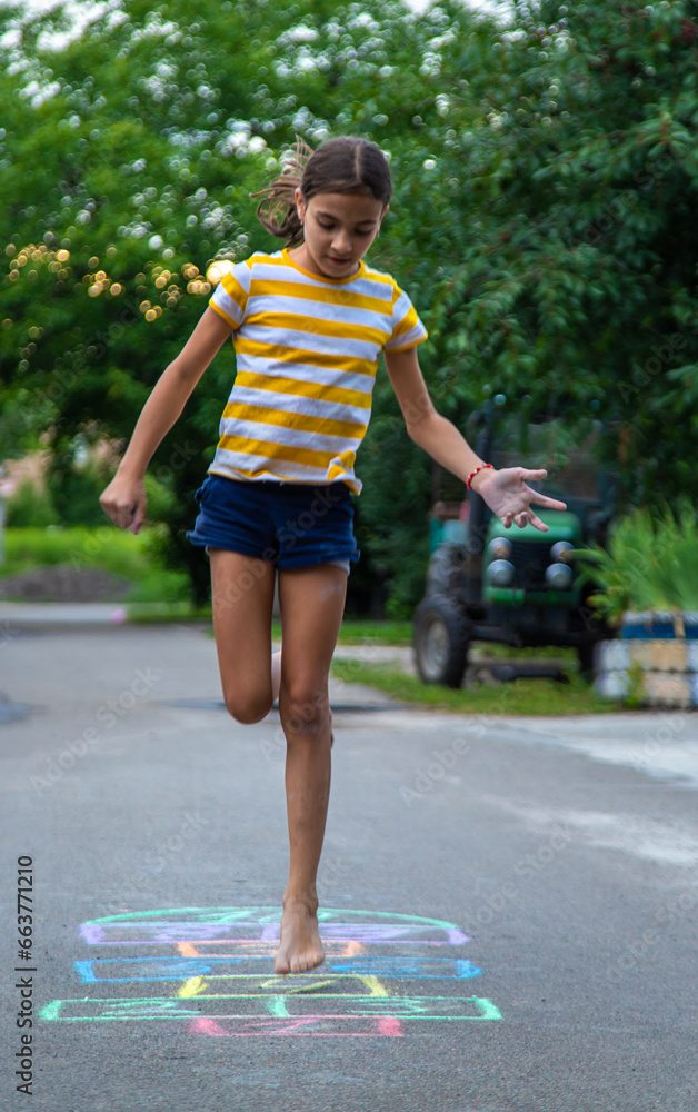 Children play hopscotch on the street. Selective focus.
