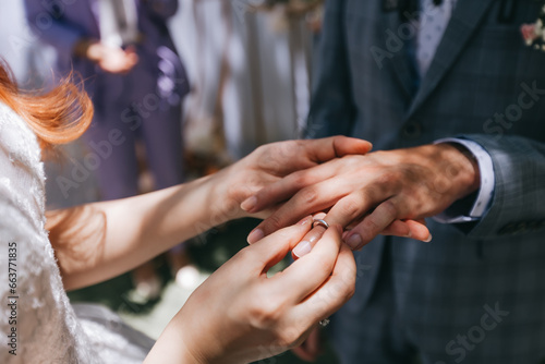 During a wedding, the bride and groom exchange wedding rings. Hand close-up