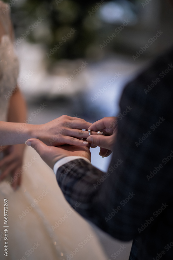 During a wedding, the bride and groom exchange wedding rings. Hand close-up