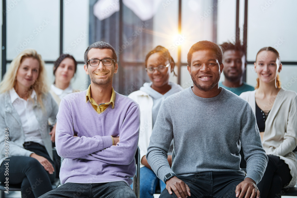 diverse young people sitting on chairs in the conference room. diverse young people sitting on chairs in the conference room.