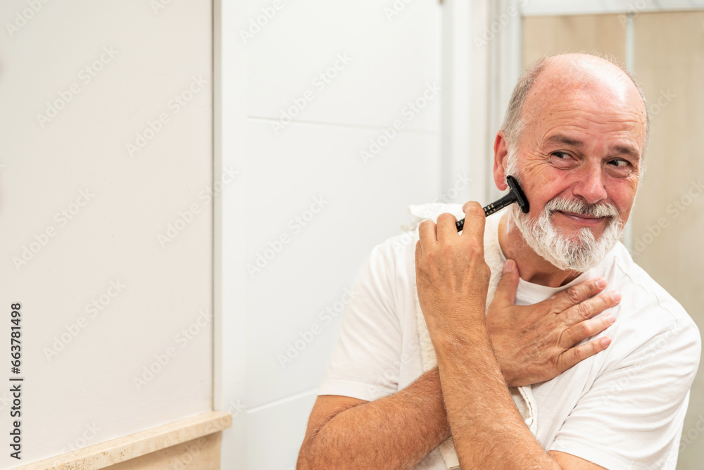Delighted senior man shaving in bathroom Delighted senior man shaving in bathroom