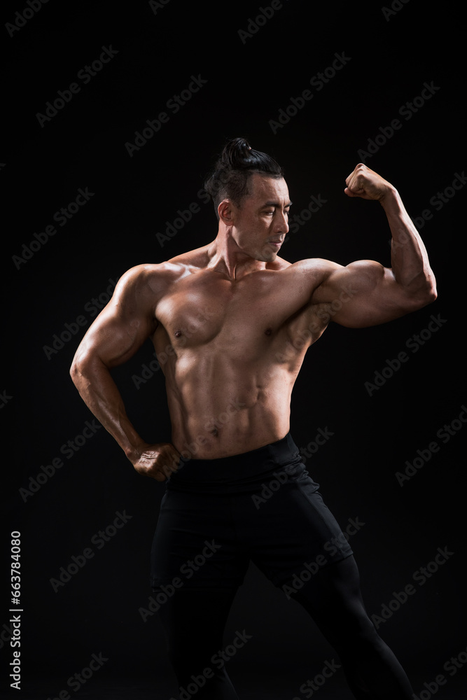 Strong, fit and sporty bodybuilder man over black background