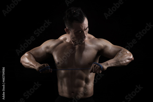 Strong, fit and sporty bodybuilder man over black background © chotiga