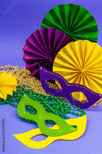 Festive Mardi Gras masquerade violet background. Fat Tuesday carnival, masks, beads, traditional decor