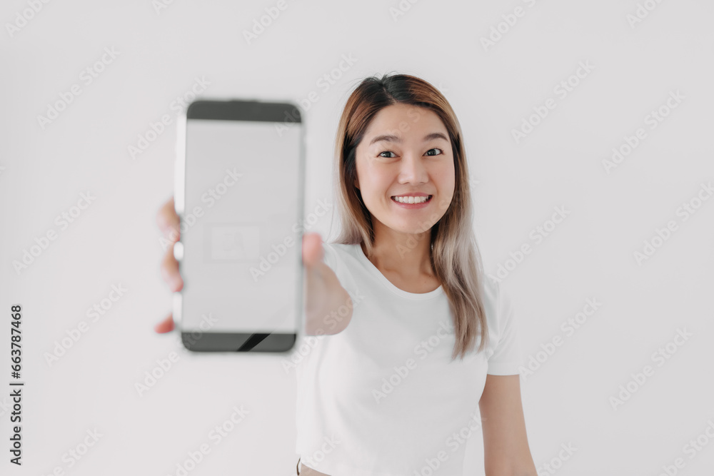 Asian Thai woman happy smiling, holding presenting smartphone and showing white blank screen, isolated on white background. Asian Thai woman happy smiling, holding presenting smartphone and showing white blank screen, isolated on white background.