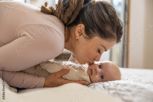 Mother with baby on the bed in the morning,enjoying in their morning routine
