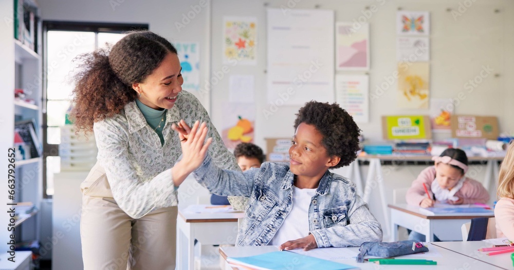 Naklejka premium Teacher woman, high five boy and classroom with achievement, success and mentorship for learning. Education, development and students with goals, knowledge and books with celebration, school and desk