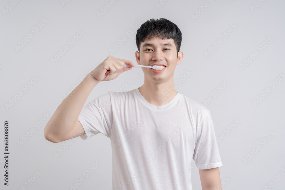 Handsome young man smiles happily and holding toothbrush. Handsome young man smiles happily and holding toothbrush.