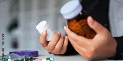 Woman hold bottle of drug tablet painkiller or vitamin supplement reading label ready to organizing medicine at home. medication healthcare concept photo