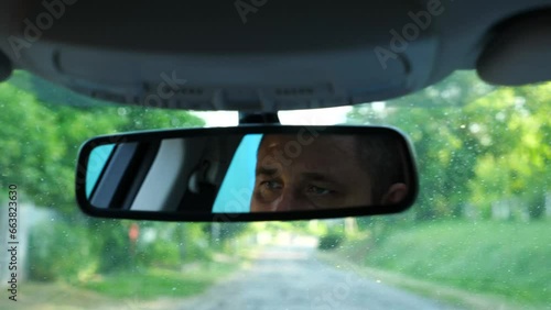 Wallpaper Mural Eyes of serious male driver reflecting of rearview mirror during riding auto. Confident man driving a motor car at countryside. Adult human looking concentrated to road during operating vehicle Torontodigital.ca