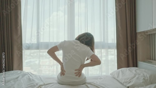 woman having back body ache during sitting on bed at home. adult female with muscle pain after Waking up due to Piriformis Syndrome, Low Back Pain and Spinal Compression. Health medical concept