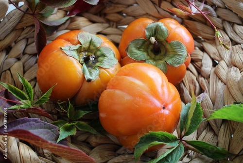 bright background. basket with ripe orange persimmons. beautiful background texture. juicy fruits. vitamins