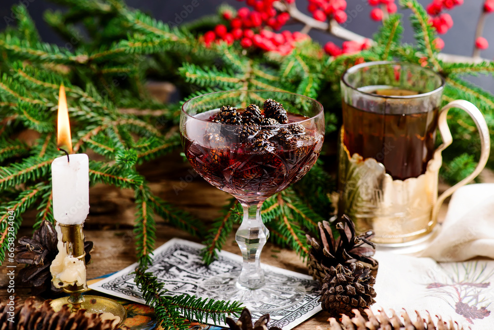 Jam from young pine cones in syrup on a background with pine branches