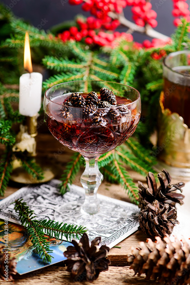 Jam from young pine cones in syrup on a background with pine branches