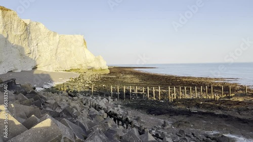 Chalk rock cliffs on the Sussex coast with pebble beach and sea on cloudy morning. Seven Sisters, South of England