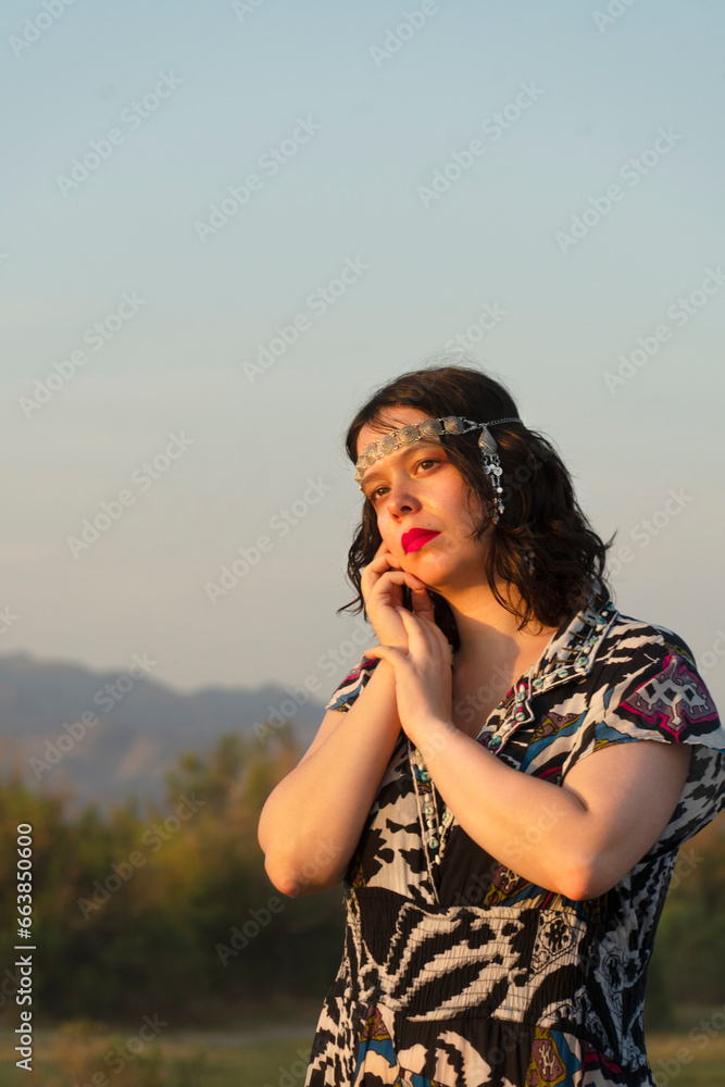 View of a beautiful woman in a colorful dress at sunset.