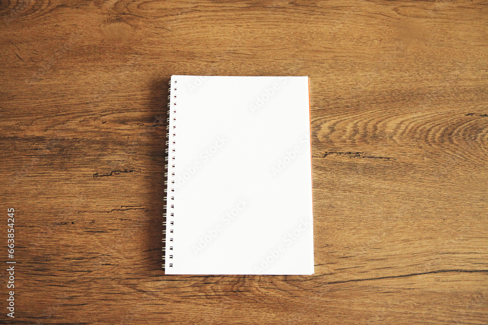 Top view of white blank notebook on wooden table Top view of white blank notebook on wooden table