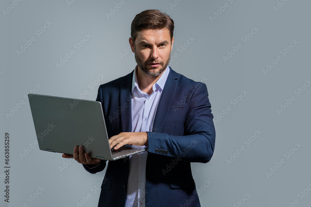 Entrepreneur working with a laptop. Business man man using laptop computer on studio background. Thoughtful caucasian businessman in eyeglasses looking at computer screen, working online, Freelance. Entrepreneur working with a laptop. Business man man using laptop computer on studio background. Thoughtful caucasian businessman in eyeglasses looking at computer screen, working online, Freelance.