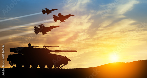 Silhouettes of army tank and fight planes on background of sunset. Military machinery. Independence day. photo