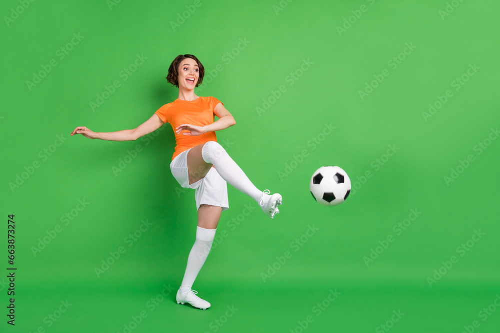 Full size portrait of positive person look empty space foot kick ball have fun isolated on green color background