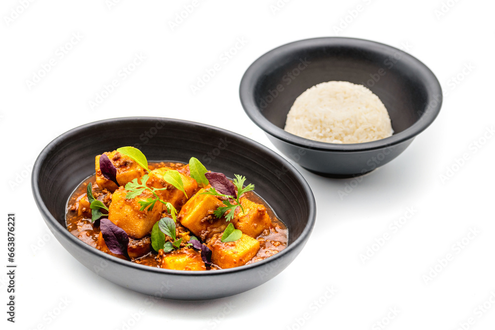 Mapo Tofu bowl with side sauces on white background