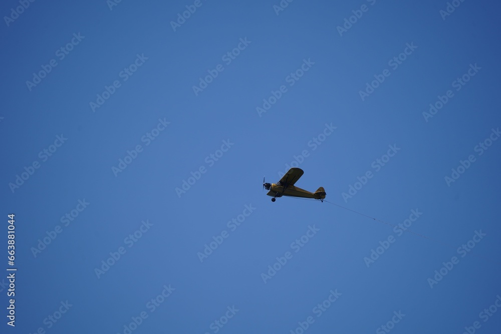 Antique airplane soaring through a crystal-clear, deep blue sky