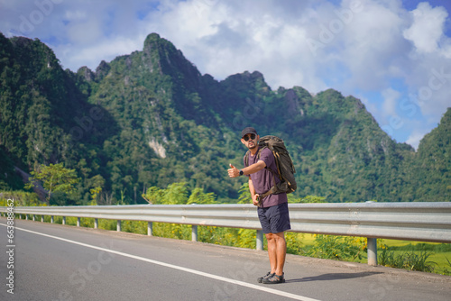 Tourist waving hand asking for help on the highway, Hitchhiking on the road, Travel man hitchhiking © Morng