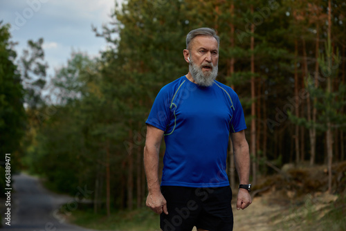Tired retired sportsman breathing hard after jogging exercise